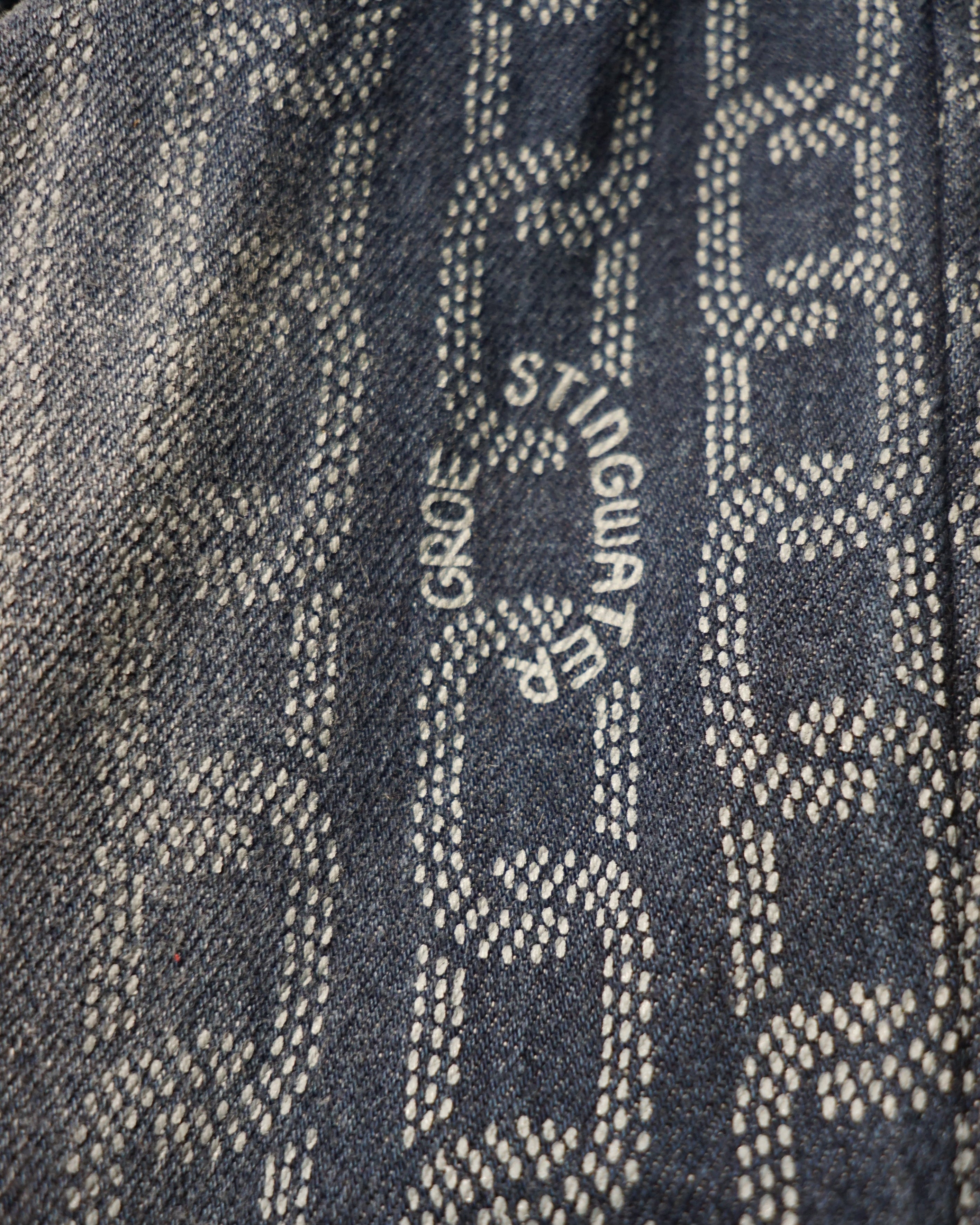 Close-up of Stingwater logo on a textured fabric background